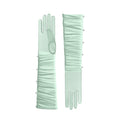 Pair of light green gloves with pearl embellishments on a white background