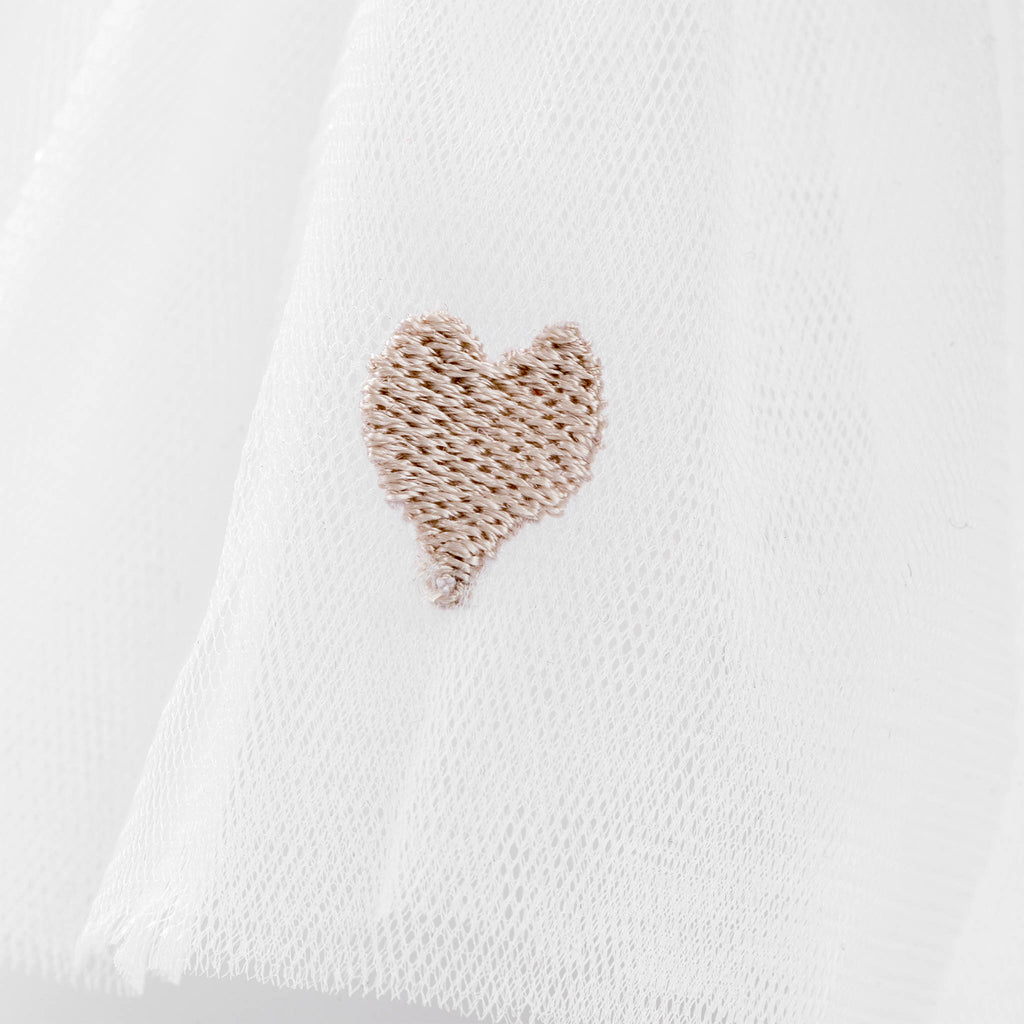 White fabric with a textured brown heart design on a white background
